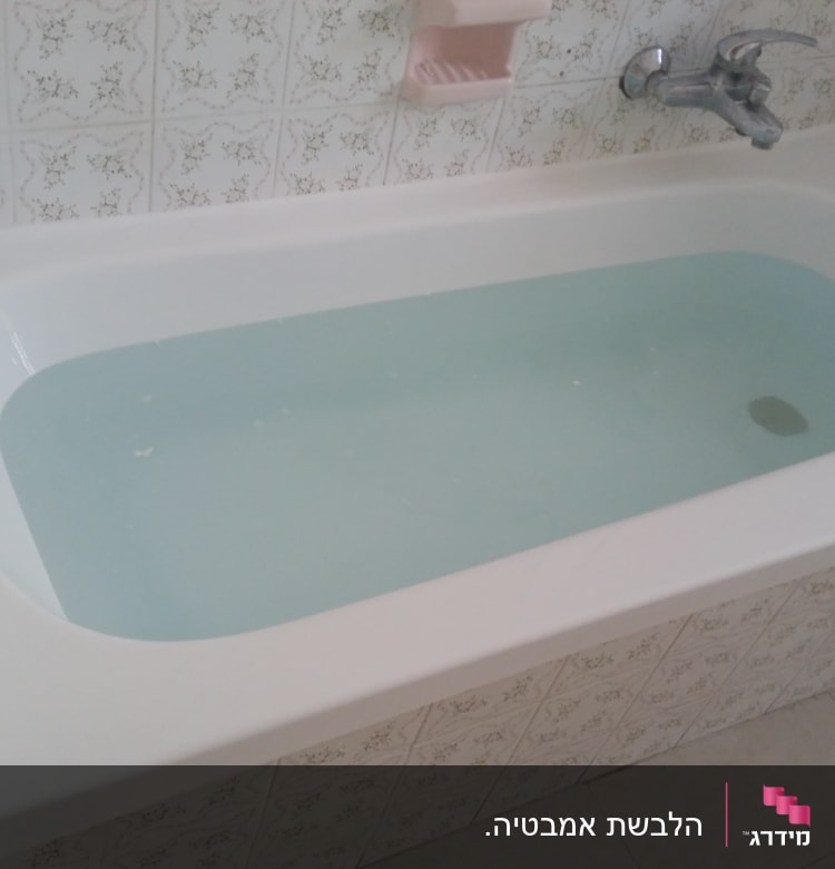 אמבטיה מלאה מים עם חיפוי אריחים דקורטיביים